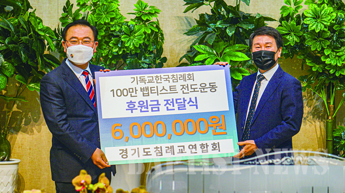 경기도침례교연합회 대표회장 김광호 목사(사진 오른쪽)가 고명진 총회장에게 100만 뱁티스트 전도운동 후원금을 전달하고 있다.